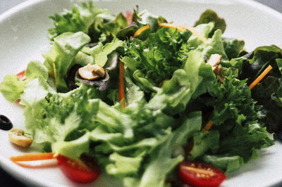 Salat mit gebratenen Pilzen und gefüllter Tomate